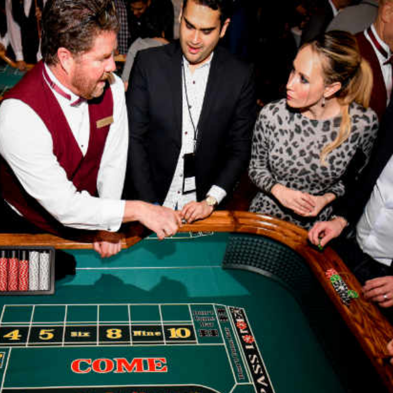 People playing Craps at a Common Cents Casino Party.